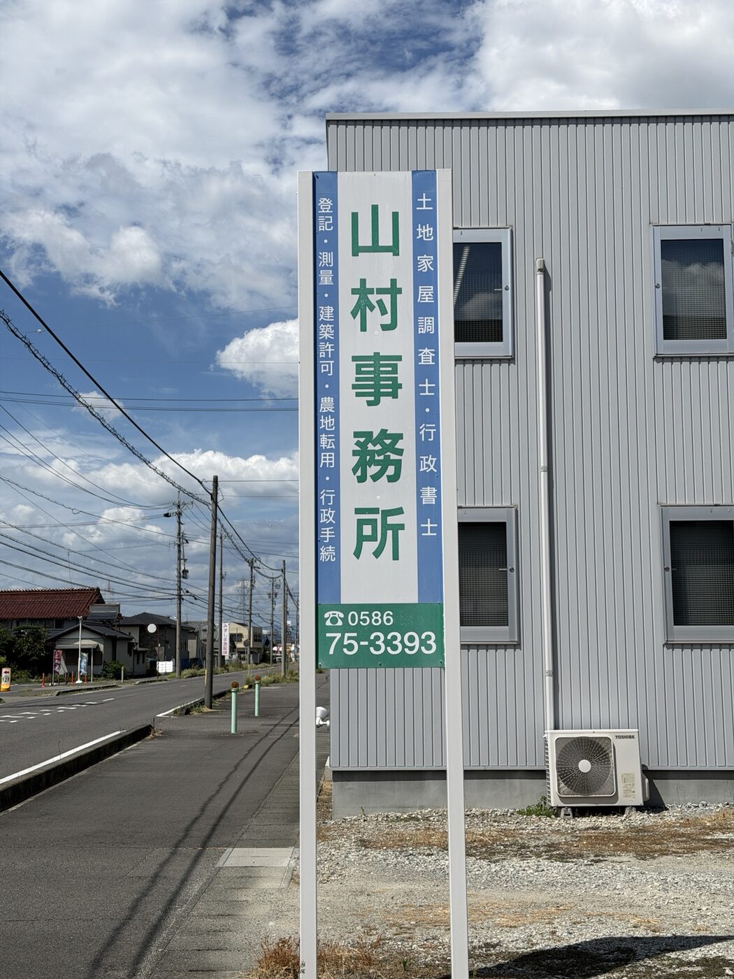 山村事務所の看板と青空